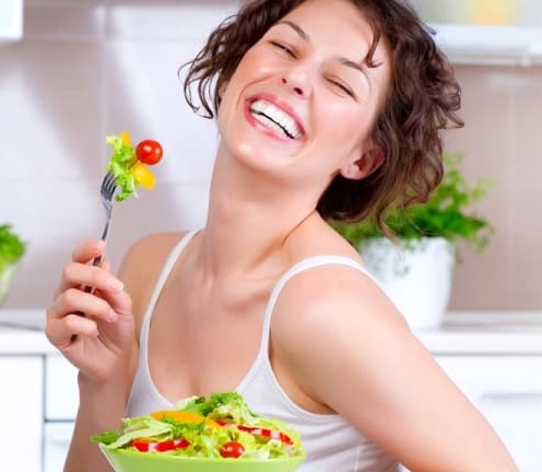 A woman inexplicably laughing alone with her salad