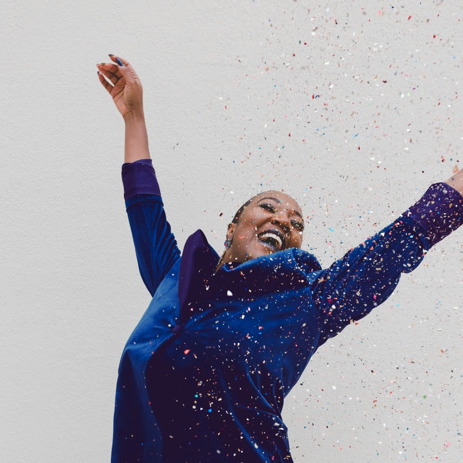 A woman celebrating amongst falling confetti