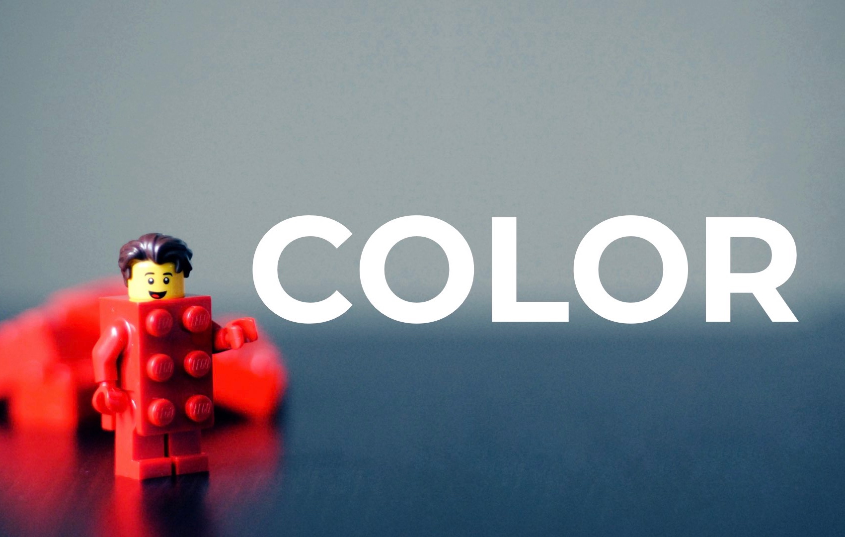 A friendly bright red LEGO man saying "Color!"