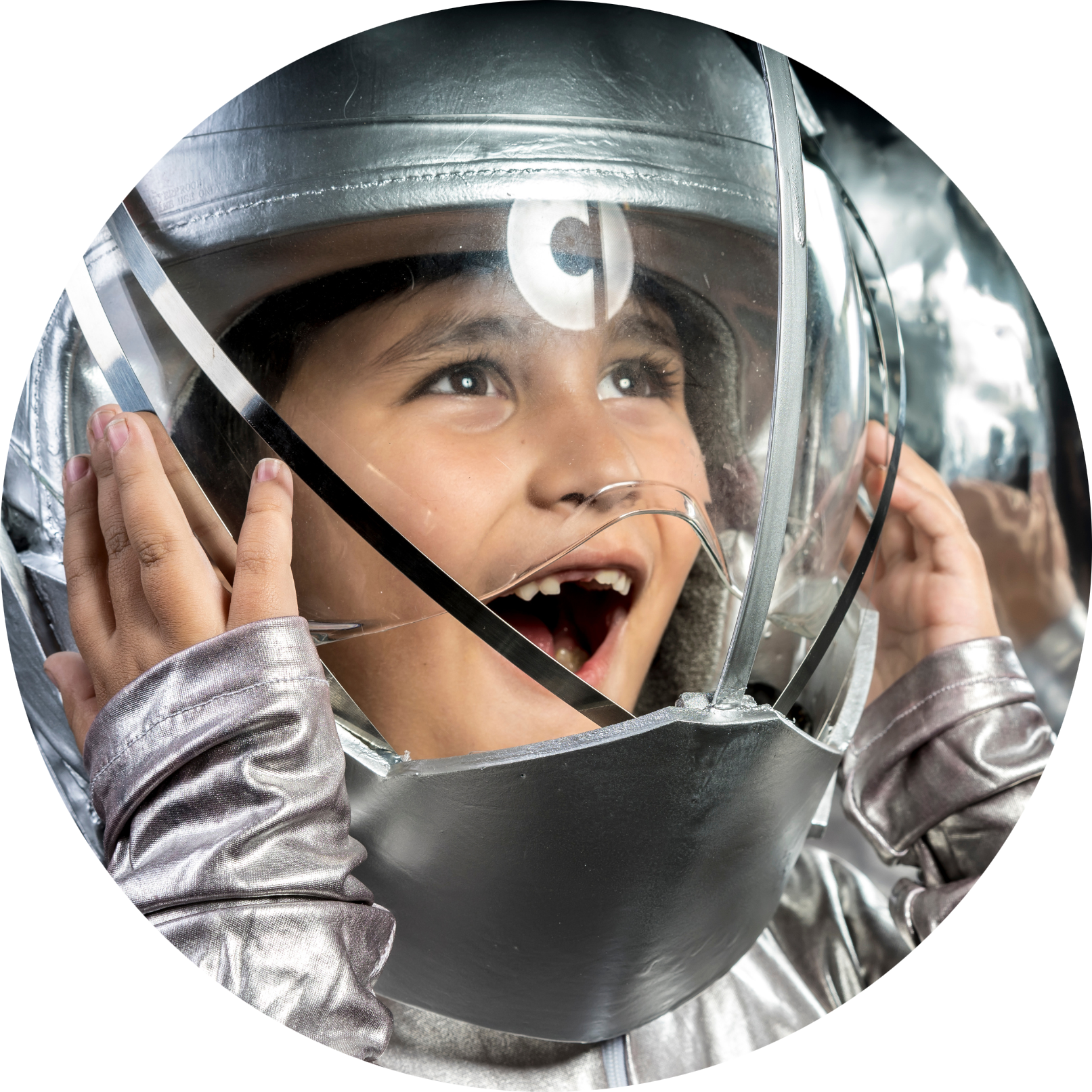 A little kid, wearing an astronaut helmet, eyes lit up in awe & wonder.